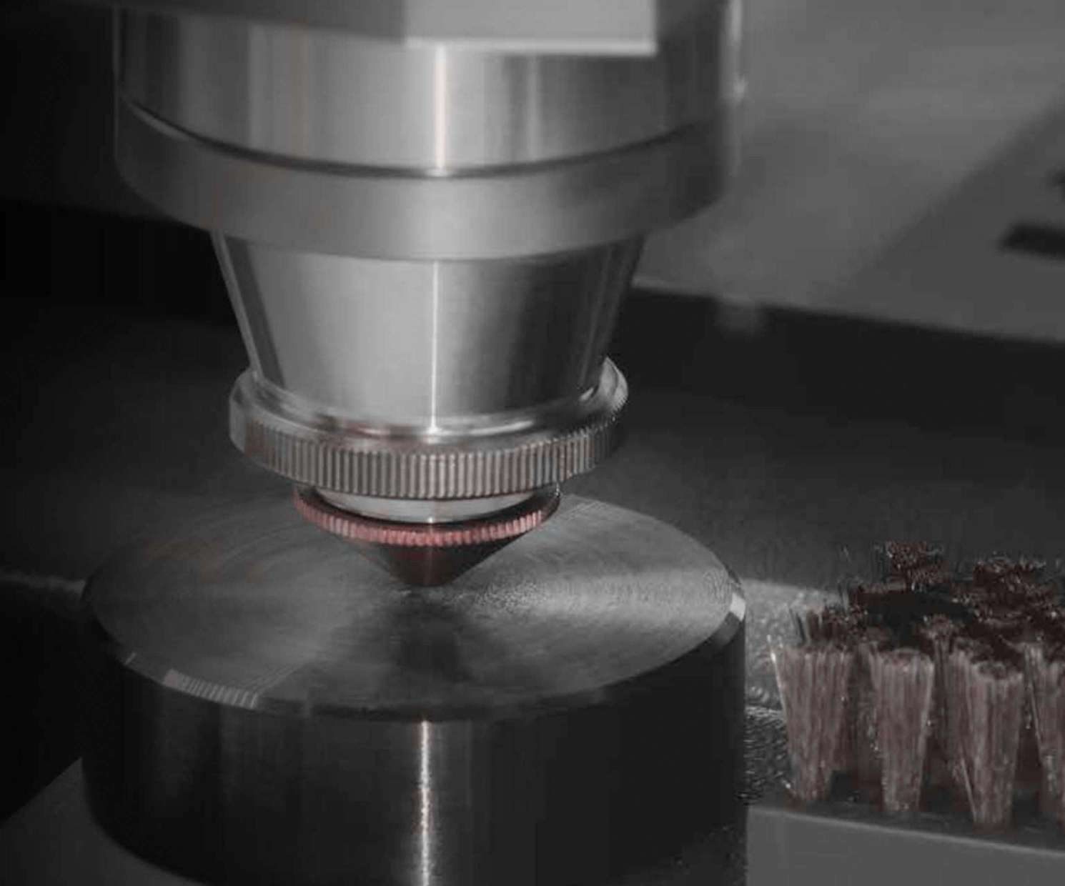 Close-up of a laser cutting head over a steel plate