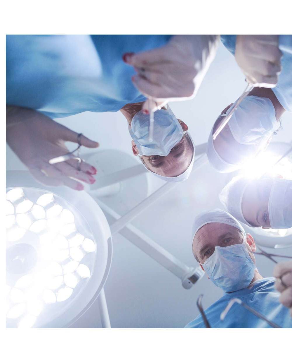 Surgeons seen from below under a surgical light